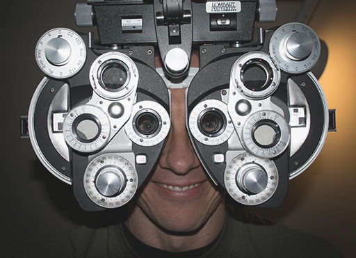 Bryan-Reavis Brian looking through a phoropter and smiling